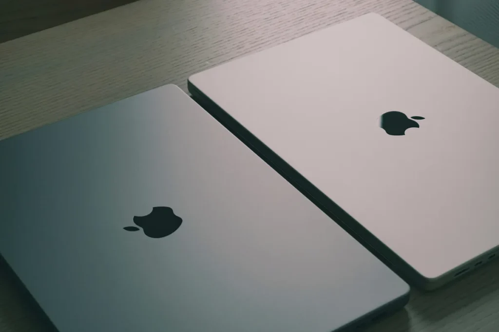 Two laptops side by side on a wooden desk